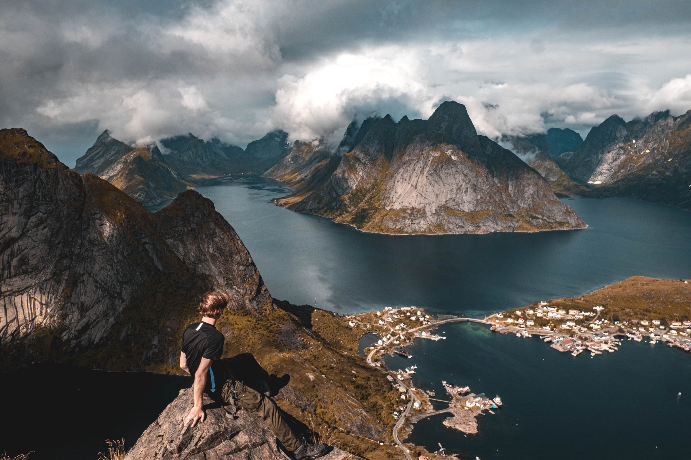 Odin Oddekalv looking out over a fjord from a clifftop in Lofoten, Norway